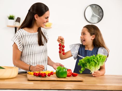 Shot of a mother and daughter having fun in the kitchen