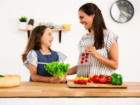 Shot of a mother and daughter having fun in the kitchen