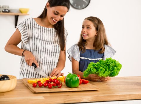 Shot of a mother and daughter having fun in the kitchen