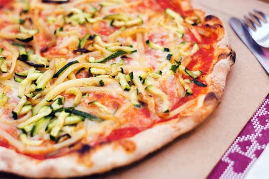 Close up of a tasty pizza with zucchini and potatoes