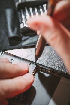 Close-up of a male hands servising broken smartphone.