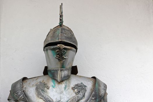 Medieval metal armor and helmet headdress on white background.