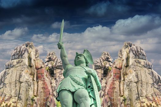 Curious and mysterious; Hermann Monument in the background, the Externsteine before dramatic sky.
