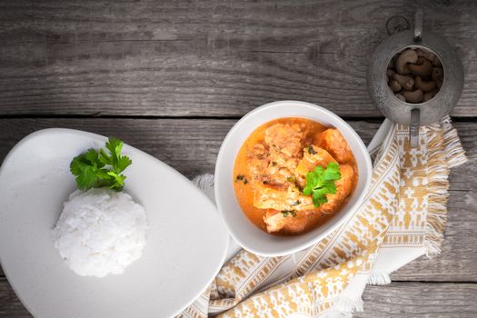 Chicken curry and rice served on a wooden surface