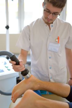 Physiotherapist performs ultrasound physical therapy treatment