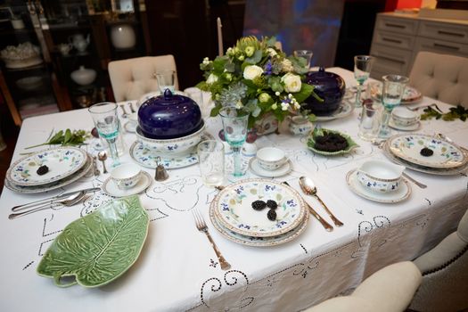 Decorated table ready for dinner. Beautifully decorated table set with flowers, candles, plates and serviettes for wedding or another event in the restaurant.