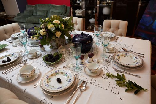 Decorated table ready for dinner. Beautifully decorated table set with flowers, candles, plates and serviettes for wedding or another event in the restaurant.