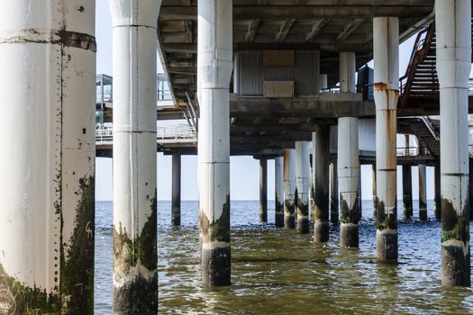 Concrete piers, concrete columns protrude from the water at the pier of Scheveningen in the Netherlands.