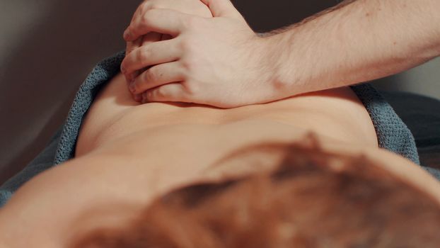 Man's hands massaging woman's back, close up