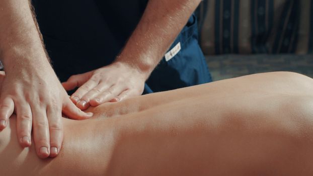 Man's hands massaging woman's back, close up