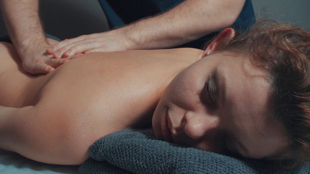 Man's hands massaging woman's back, close up