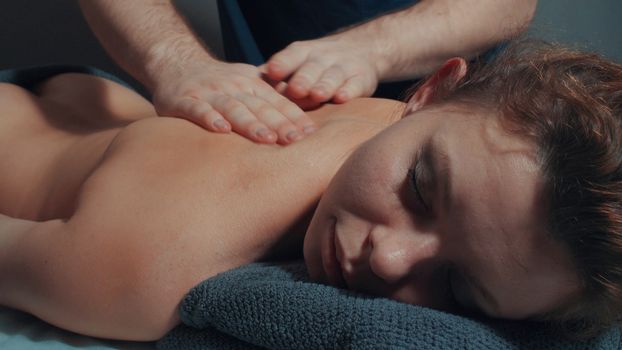 Man's hands massaging woman's back, close up