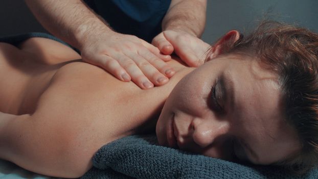 Man's hands massaging woman's back, close up