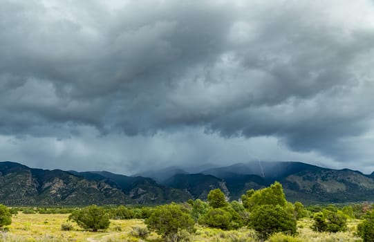 A lightning strike highlights an afternoon thunderstorm along North Zapata Ridge in the Sangre de Cristo Mountain Range of the southern Rocky Mountains.
