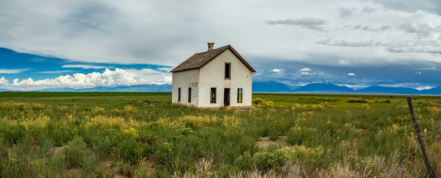 A empty house sits abandoned along a dirt road in the San Luis Valley of the Rocky Mountains in Colorado