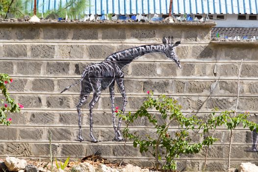 Giraffe draw on a wall of raw blocks in the town of Bamburi in Kenya