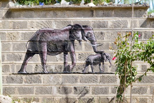 Elephant and his small drawing on a wall of raw blocks in the town of Bamburi in Kenya