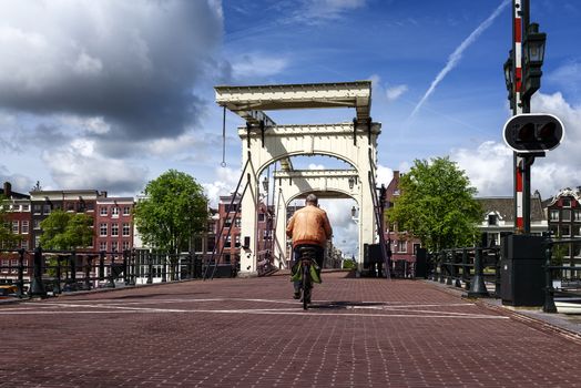 The Magere Brug. A man in a bycicle is accrossing the Skinny Bridge in Amsterdam, Netherlands