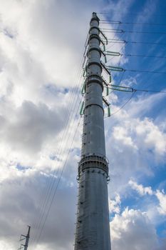 High-voltage power lines and insulators over blue sky background