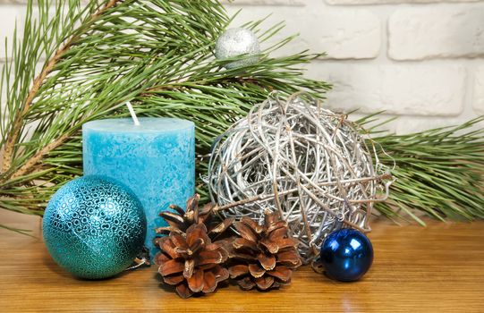 New Year 2017 composition with bright blue ball and candle on wooden background woth fir tree branch