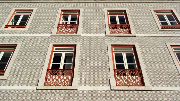 Detail of an old building with portuguese tiles and red and white windows, Lisbon, Portugal