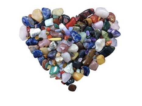 Beautiful background of colorful various gemstones made in heart shape on white isolated.