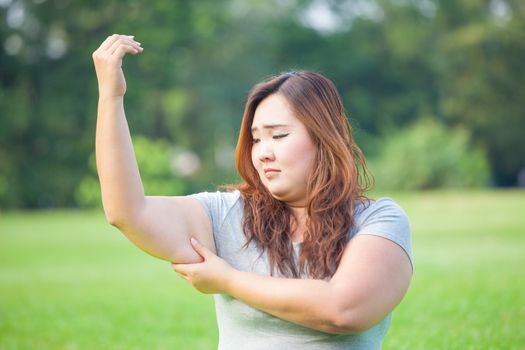 Young asian fat woman checking her arm fat