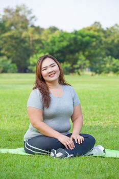 Happy fatty asian woman posing outdoor in a park