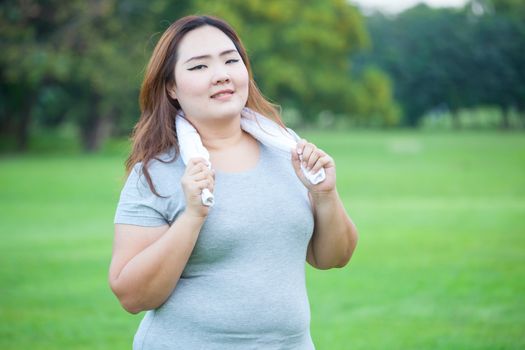 Happy fatty asian fit woman posing outdoor in a park