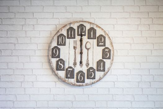 Retro vintage wall clock on white brick wall