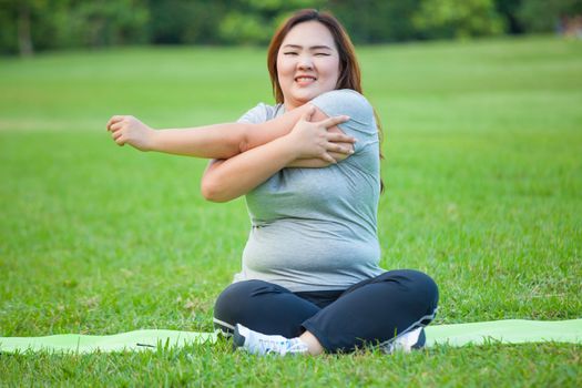 Happy fatty asian woman posing outdoor in a park