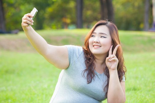 Pretty fat female takes travel selfie at the park