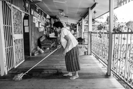 Black and white image of Senior asian woman Cleaning house