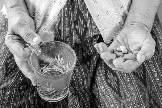 Black and white image of Senior asian woman  with medicine