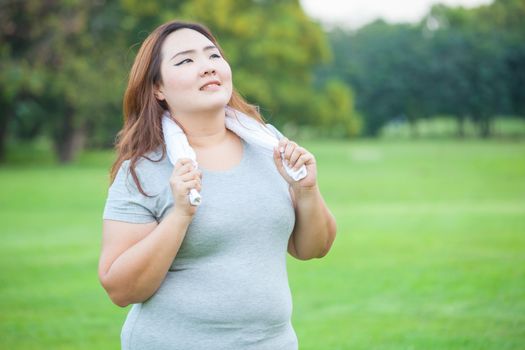 Happy fatty asian fit woman posing outdoor in a park