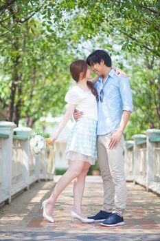 Loving asian couple under tree in the park