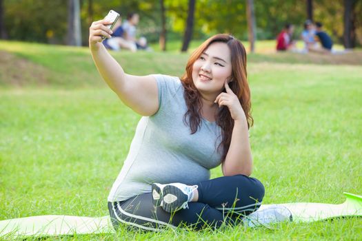 Pretty fat female takes travel selfie at the park