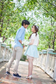 Loving asian couple under tree in the park