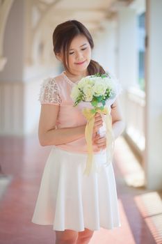 Young asian cute woman smelling white flowers