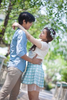 Loving asian couple under tree in the park