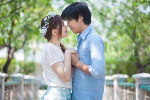 Loving asian couple under tree in the park