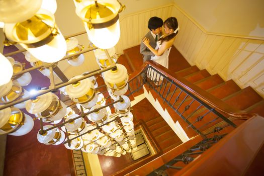 Beautiful asian young bride and groom kissing on stairs