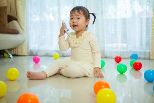 Portrait of pretty asian little girl talking on mobile phone