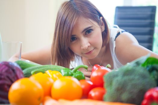 Happy asian woman cooking vegetables green salad in the kitchen