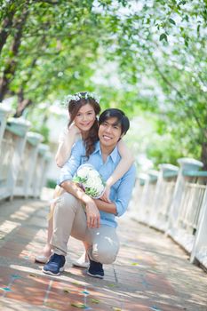 Loving asian couple under tree in the park