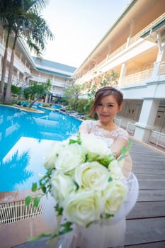 Young asian cute woman smelling white flowers