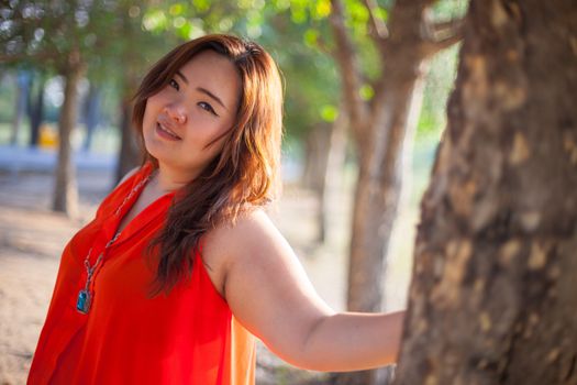 Happy fatty asian woman posing outdoor in a park