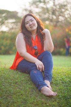 Happy fatty asian woman posing outdoor in a park