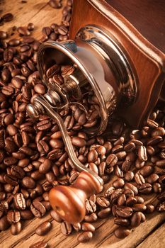 Vintage manual coffee grinder with coffee beans on wood table