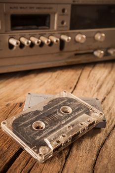 Old cassette tapes and cassette player on wooden surface